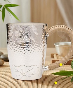 Sterling silver mug with woven rattan handle £1800 order number 880. This sterling silver mug with woven rattan handle features intricate motifs